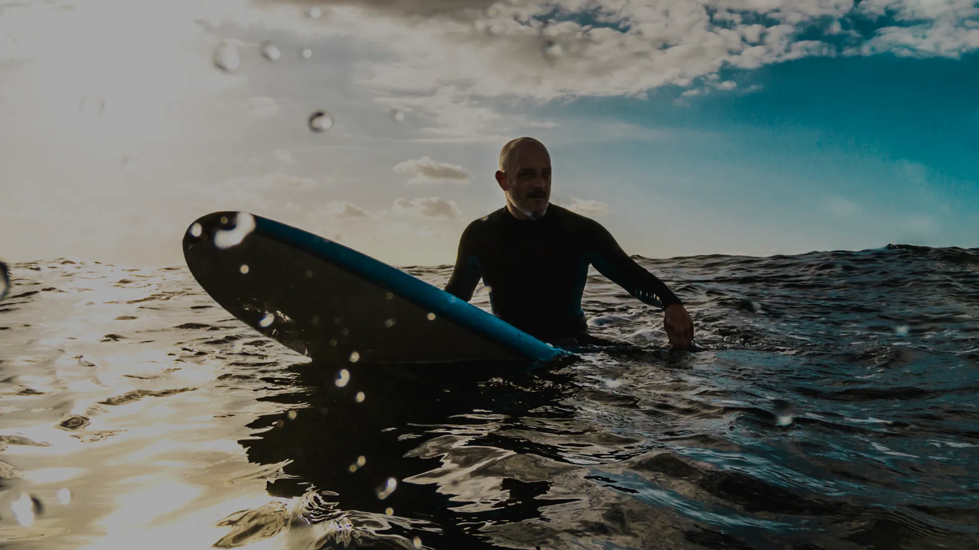 Persona en el mar con su tabla de surf